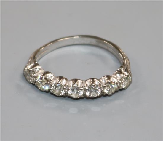 A white metal and seven stone diamond half hoop ring, size J.